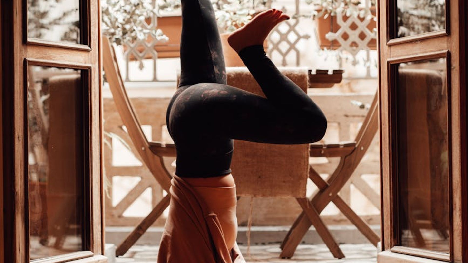 A person in a calm yoga pose in a minimalist dark room.